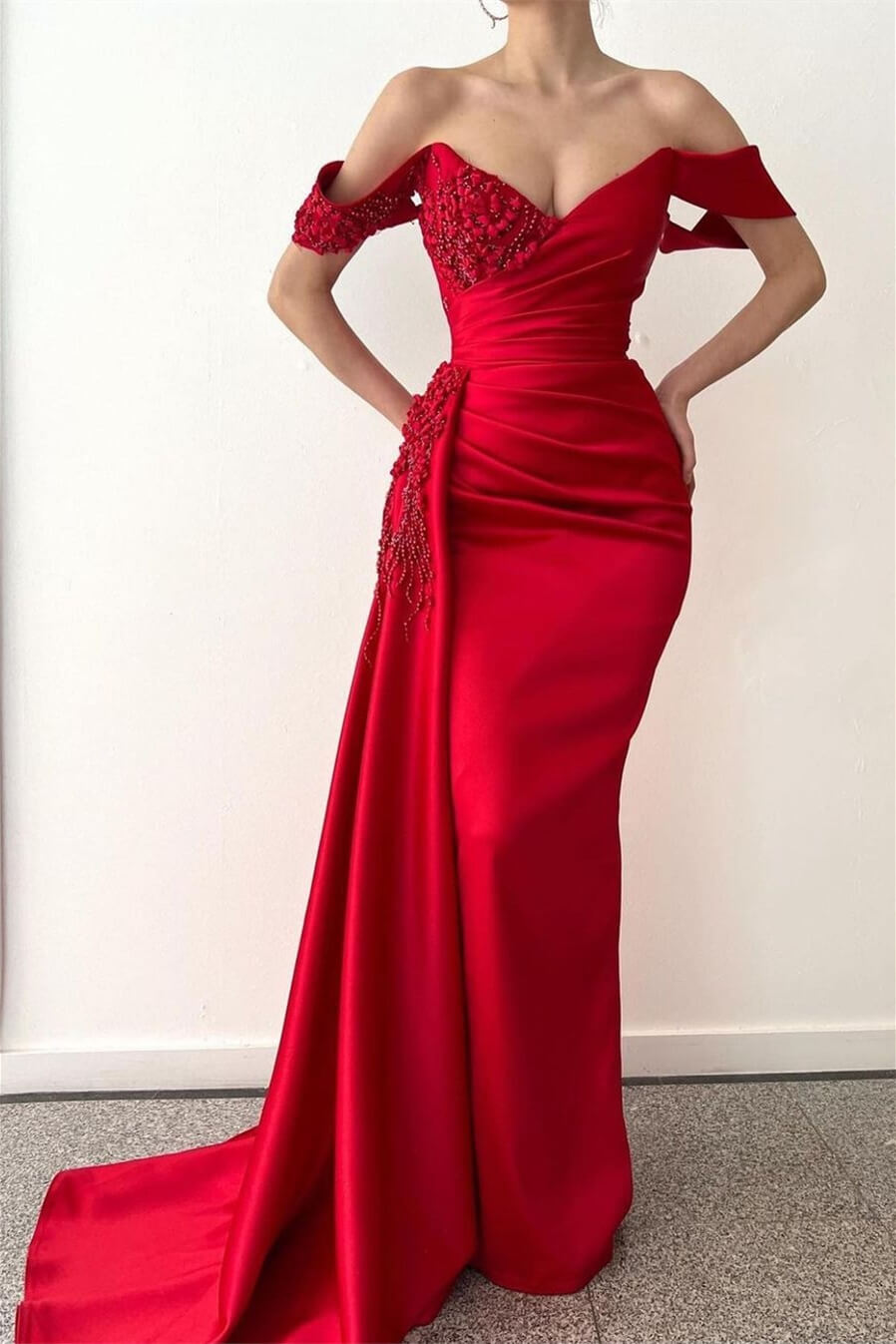 Deslumbrante vestido de fiesta de sirena rojo con detalles de cuentas y un coqueto estilo con hombros descubiertos.