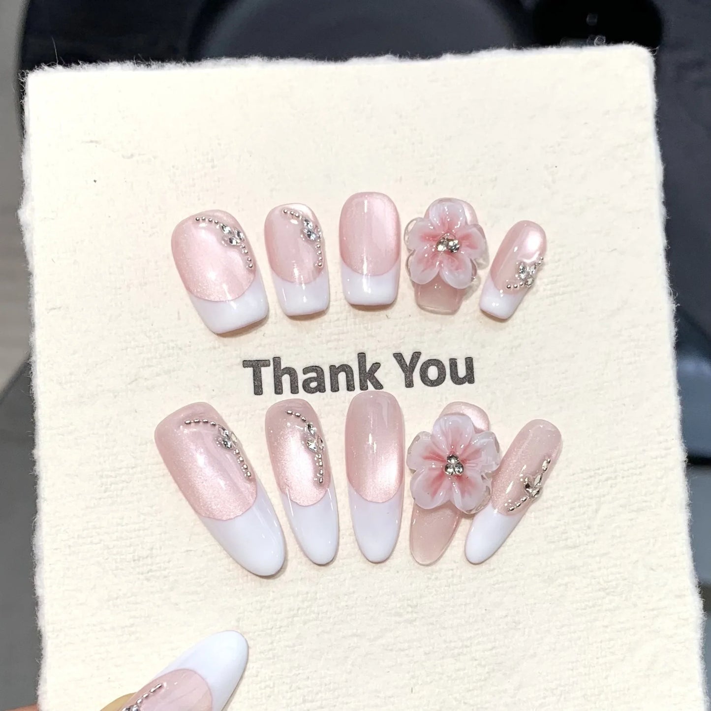 Manicura francesa de ojo de gato con diseño floral 3D, hecha a mano y que resalta la piel clara.