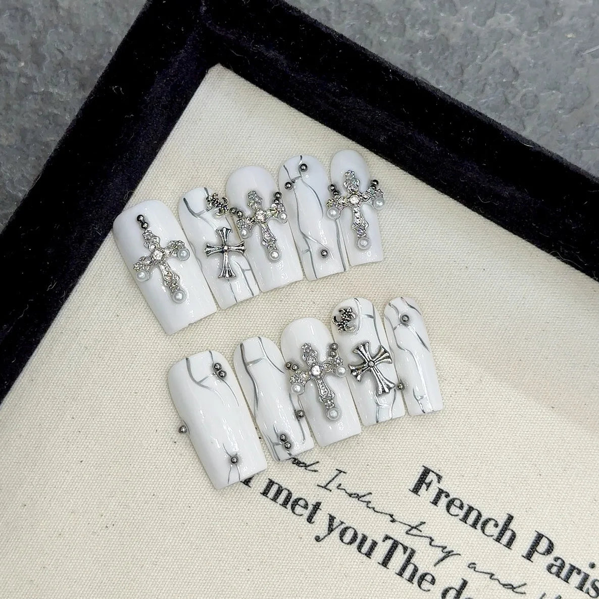 Uñas postizas blancas con forma de cruz de diamante y cuentas de acero para uñas postizas.
