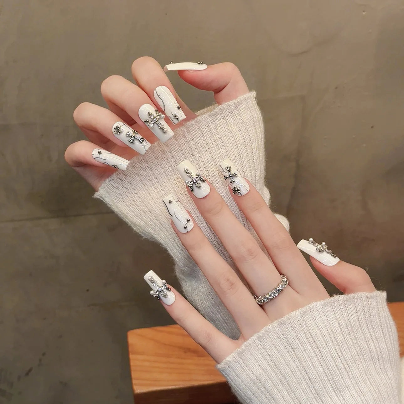 Uñas postizas blancas con forma de cruz de diamante y cuentas de acero para uñas postizas.