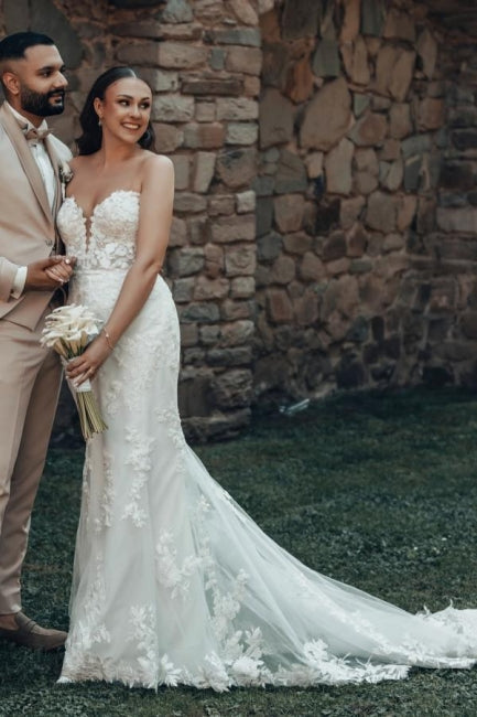 Vestido de novia largo color marfil con cola, estilo sirena, sin tirantes y encaje.
