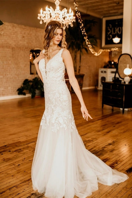 Elegante vestido de novia de tul con escote en V, sin mangas y volantes.