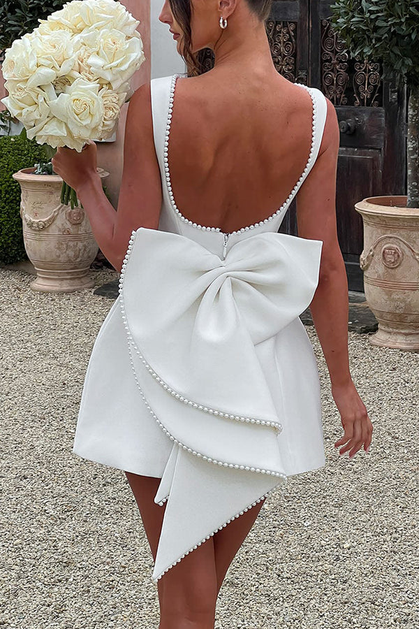 Stilvolles, perlenverziertes, schmal geschnittenes Minikleid mit großer Schleife
