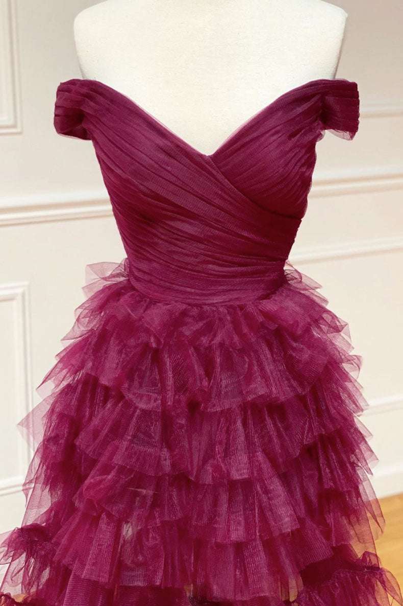 Vestido de fiesta plisado con hombros descubiertos en color baya oscuro, transparente y escalonado