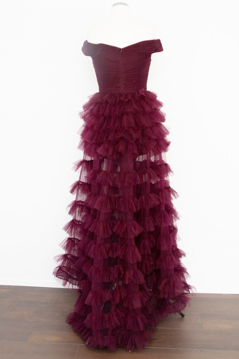 Vestido de fiesta plisado con hombros descubiertos en color baya oscuro, transparente y escalonado