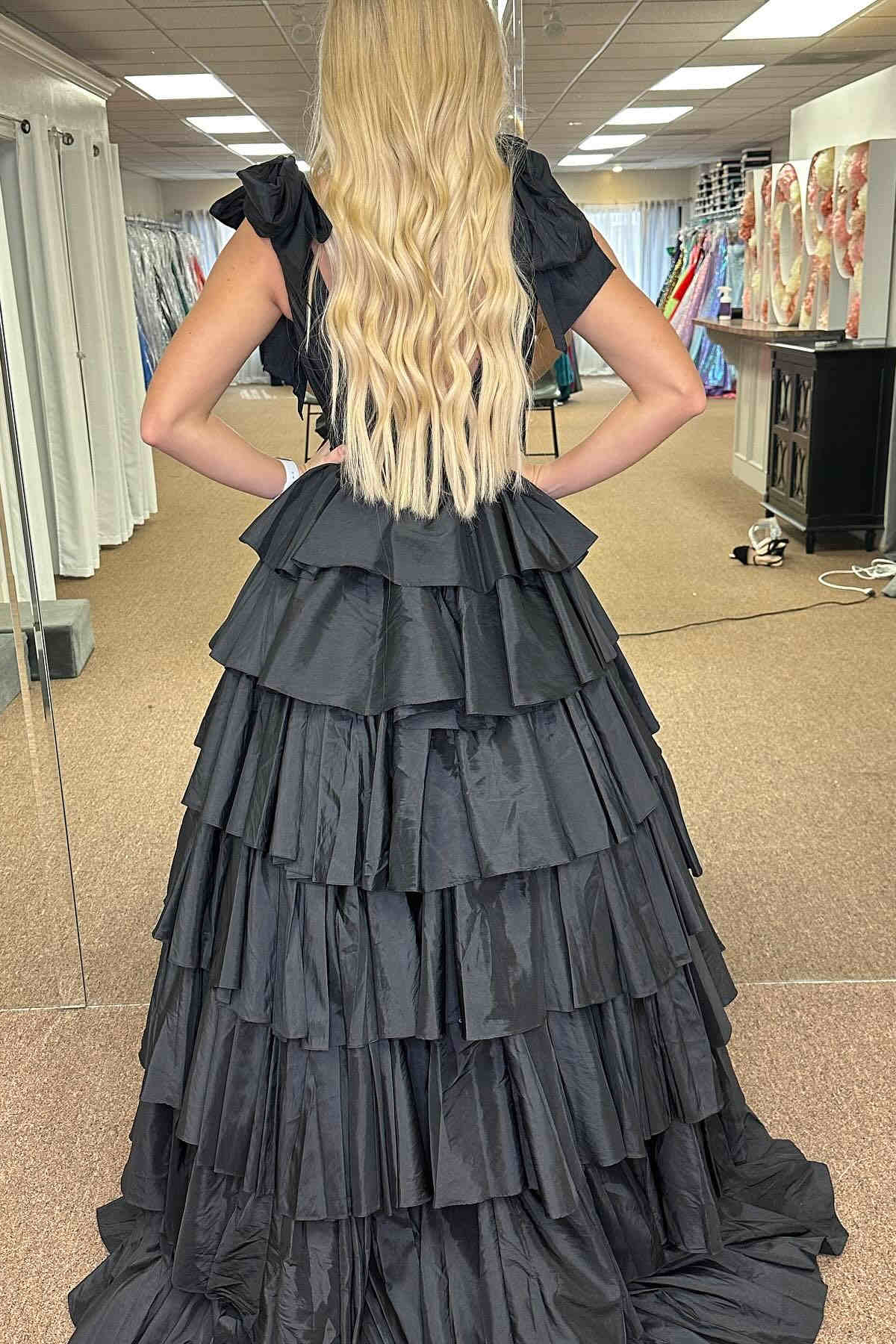 Vestido de gala fucsia con escote en V pronunciado, tirantes con lazo y volantes