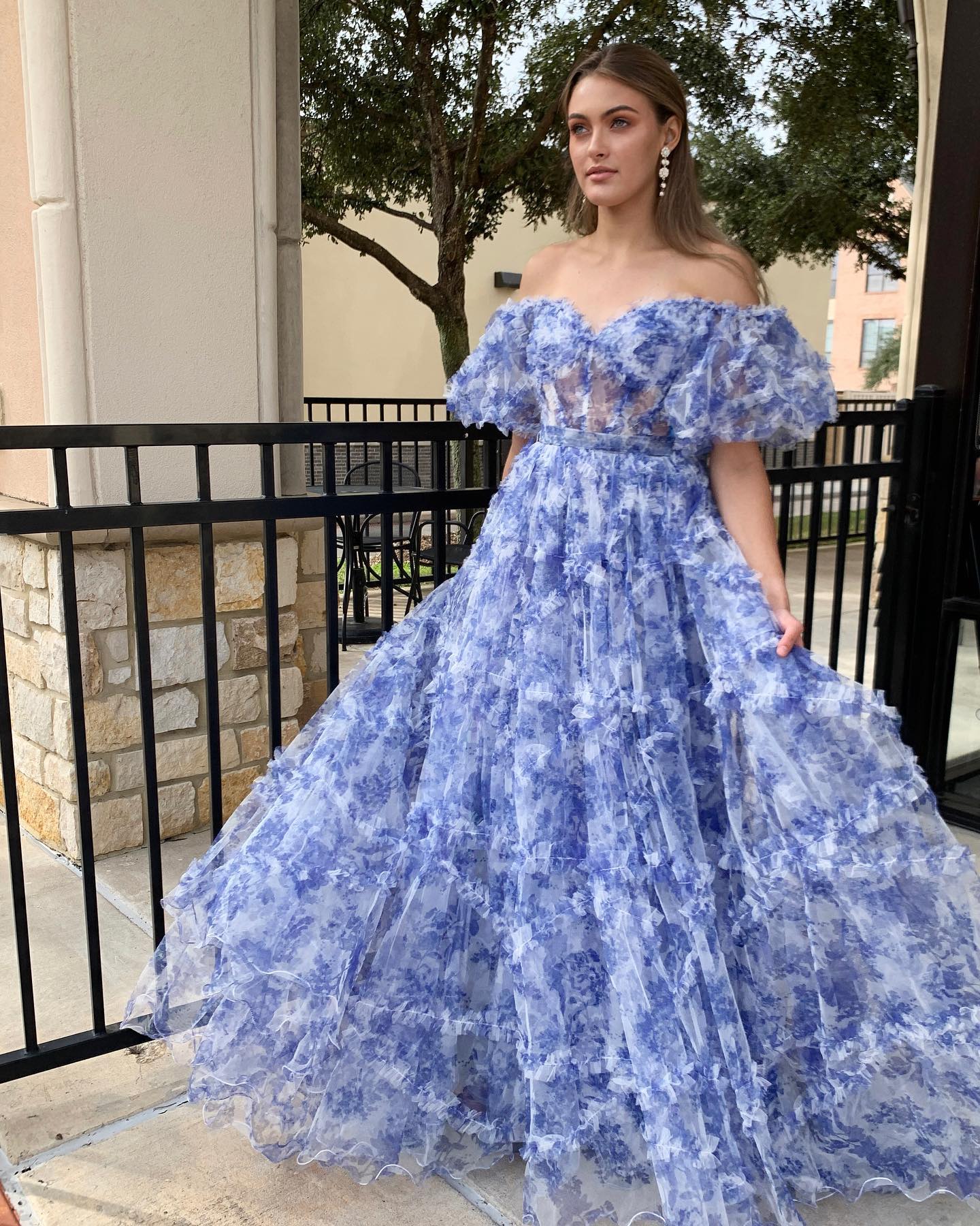 Vestido de fiesta de tul con volantes y estampado floral azul con hombros descubiertos