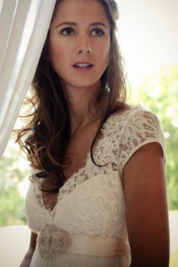 Vestido de novia con escote en V, mangas cortas, cola larga, espalda descubierta y faja