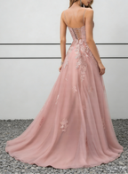 Abito lungo in tulle rosa cipria con applicazioni di pizzo, spalline sottili e schiena allacciata