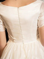 Back view of 1950s vintage short A-line wedding dress with sleeves, zipper and tea-length skirt.