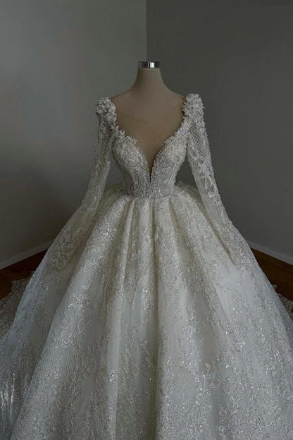 Impresionante vestido de novia largo estilo princesa, corte A, escote en V, encaje, cuentas y mangas largas.