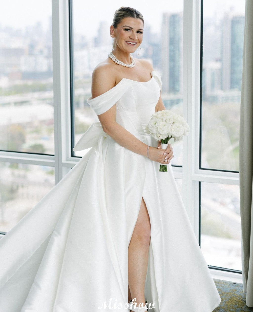 Bellissimi abiti da sposa bianchi in raso, linea a trapezio, scollo a barchetta, senza maniche, con volant e spacco frontale