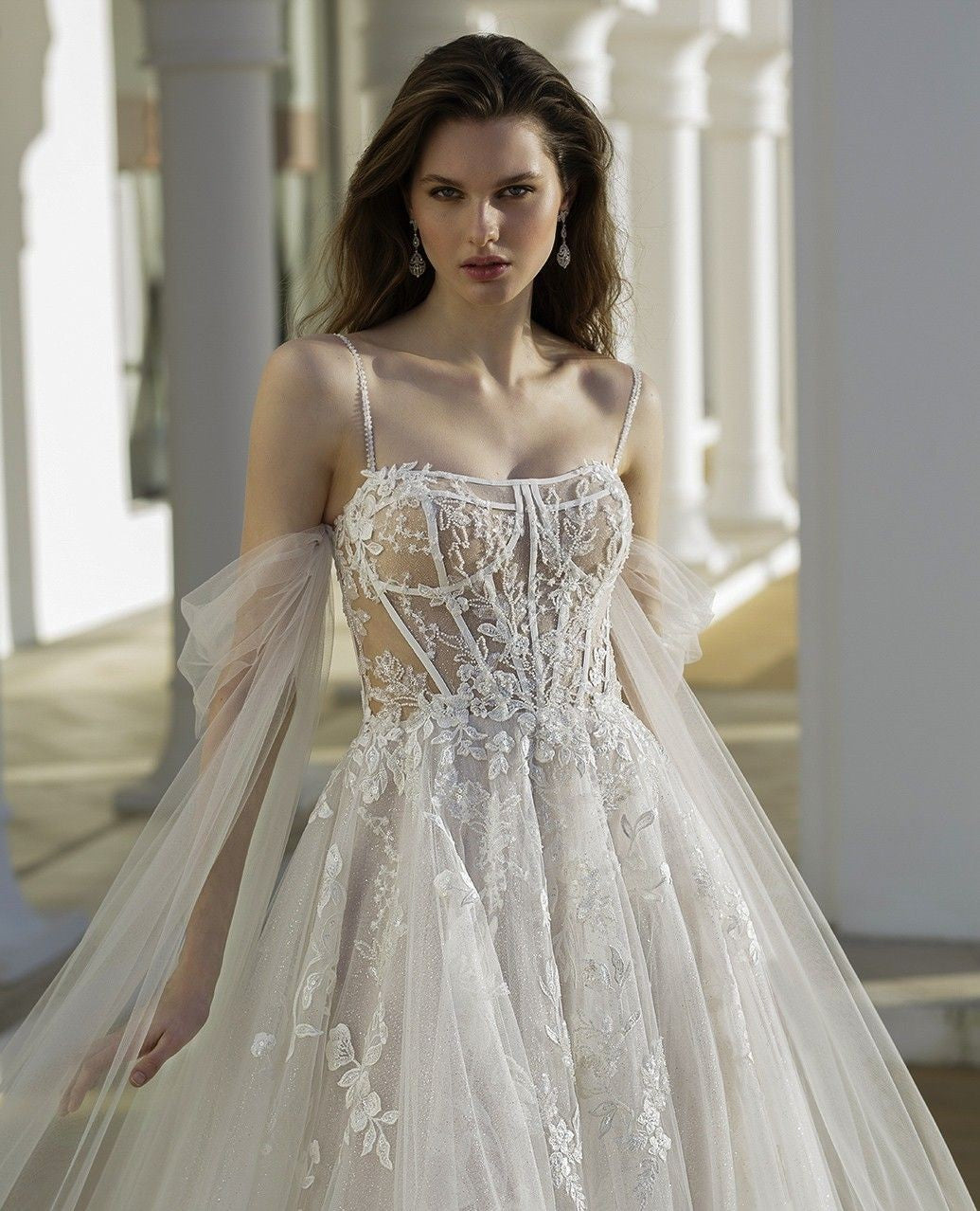 Bellissimi abiti da sposa bianchi con gonna a trapezio in tulle e pizzo, spalline sottili, maniche lunghe e applicazioni