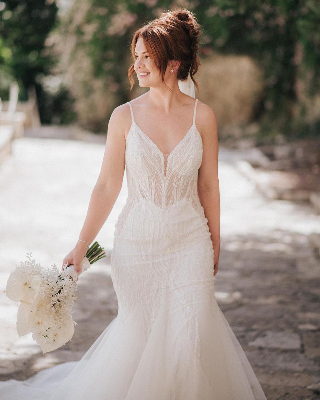 Hermoso vestido de novia largo de sirena con tirantes finos, escote en V, encaje, sin mangas y espalda descubierta.