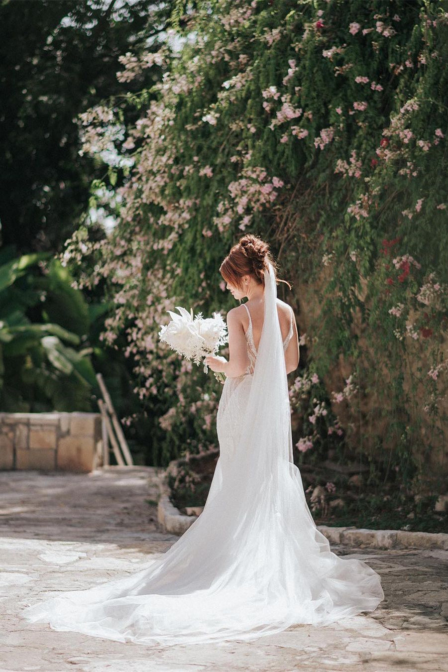 Hermoso vestido de novia largo de sirena con tirantes finos, escote en V, encaje, sin mangas y espalda descubierta.