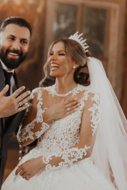 Elegante vestido de novia blanco largo de tul con encaje y mangas largas.