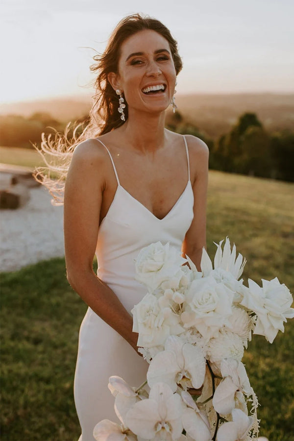 Vestido de novia clásico color marfil con tirantes finos, escote en V y corte playero sencillo