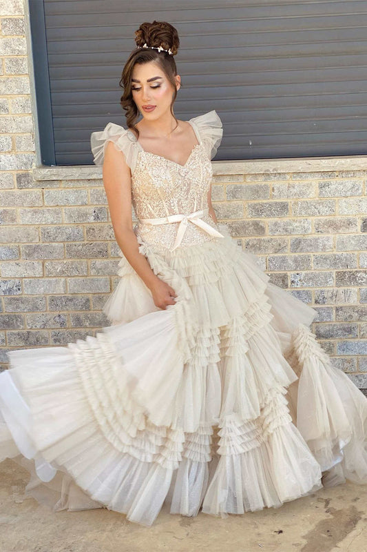 Vestido de fiesta de tul con escote en V, apliques color marfil y mangas volantes.