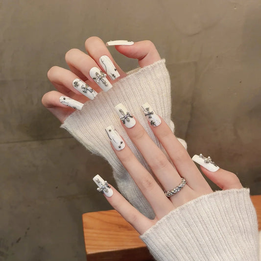 Uñas postizas blancas con forma de cruz de diamante y cuentas de acero para uñas postizas. 