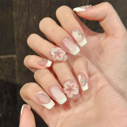 Manicura francesa de ojo de gato con diseño floral 3D, hecha a mano y que resalta la piel clara. 