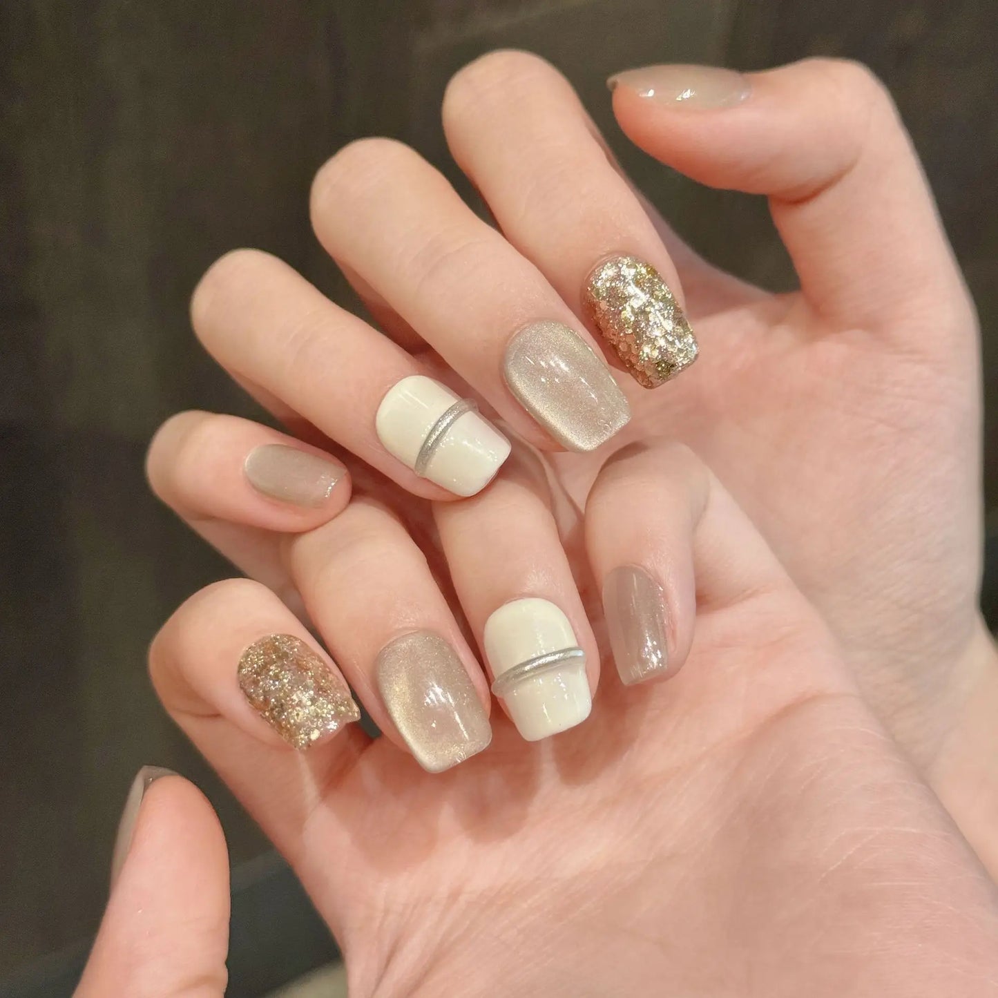 Uñas cortas minimalistas con acabado de espejo, color blanco leche, champán, dorado y brillante, con acabado de ojo de gato. 