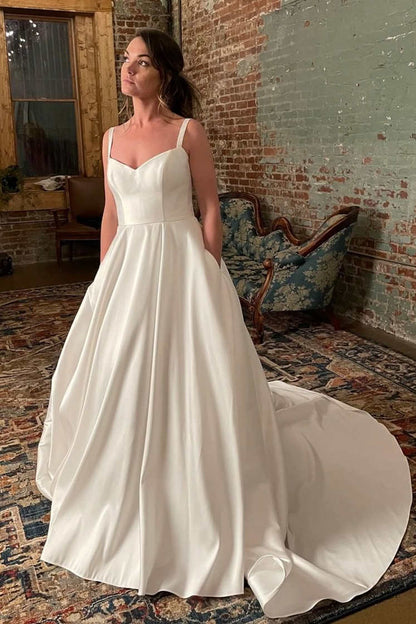 Schlichtes elfenbeinfarbenes Brautkleid mit breiten Trägern und Taschen