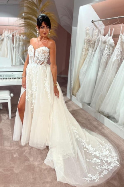 Abito da sposa incantevole senza maniche, lunghezza fino al pavimento, con scollo a cuore, gonna a trapezio divisa davanti, in tulle e pizzo con applicazioni