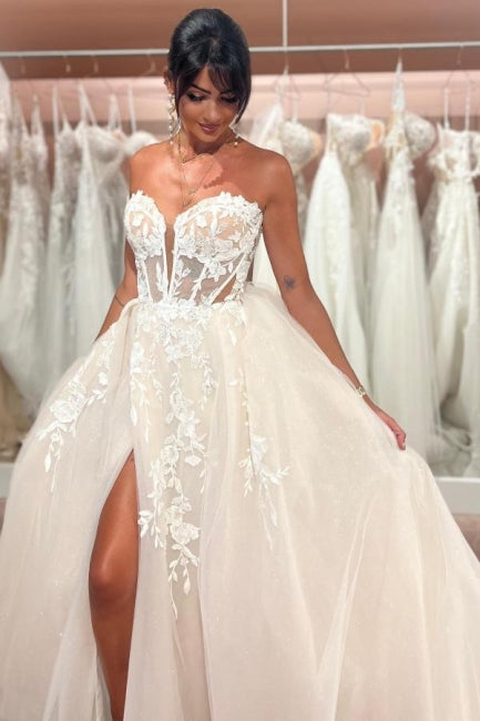 Abito da sposa incantevole senza maniche, lunghezza fino al pavimento, con scollo a cuore, gonna a trapezio divisa davanti, in tulle e pizzo con applicazioni
