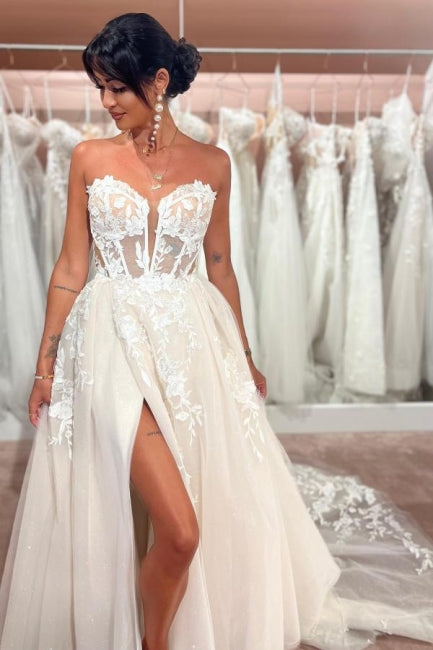 Abito da sposa incantevole senza maniche, lunghezza fino al pavimento, con scollo a cuore, gonna a trapezio divisa davanti, in tulle e pizzo con applicazioni