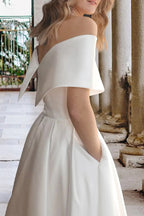 Vestido de novia playero de satén con hombros descubiertos y bolsillos, largo hasta la rodilla