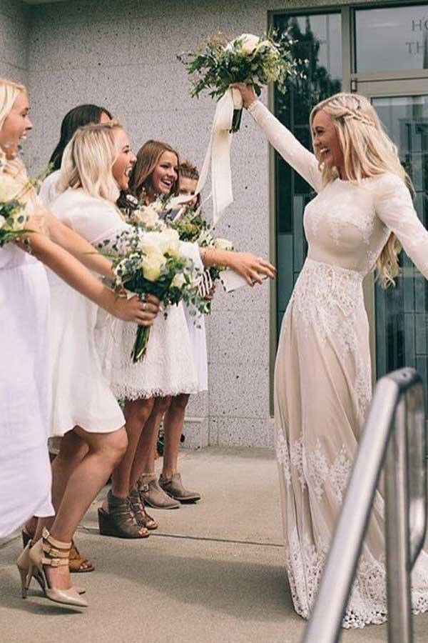 Vestido de novia de tul color marfil con mangas largas y corte barco y apliques