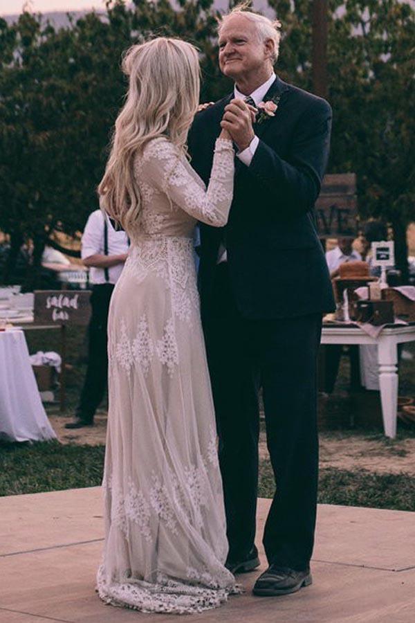 Vestido de novia de tul color marfil con mangas largas y corte barco y apliques