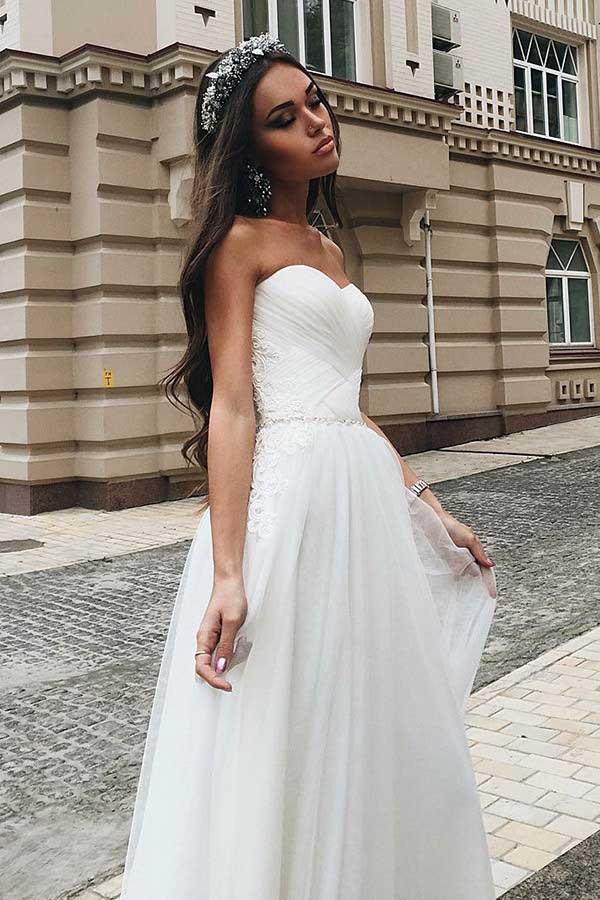 Abito da sposa in tulle con gonna a linea ad A, scollo a cuore e strascico, decorato con applicazioni