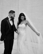 فستان زفاف أبيض طويل بأشرطة رفيعة من الدانتيل على شكل حورية البحر بدون أكمام مزين بالتطريزات