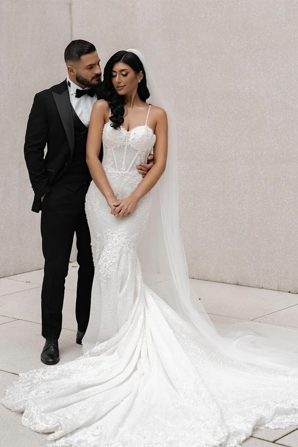 فستان زفاف أبيض طويل بأشرطة رفيعة من الدانتيل على شكل حورية البحر بدون أكمام مزين بالتطريزات