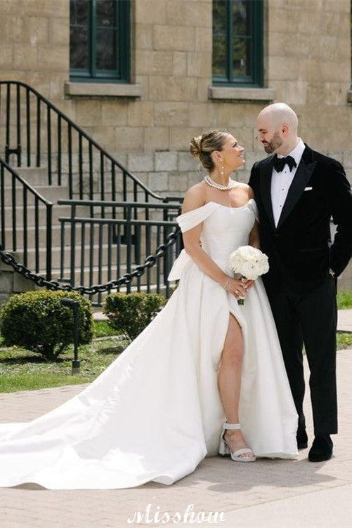 Bellissimi abiti da sposa bianchi in raso, linea a trapezio, scollo a barchetta, senza maniche, con volant e spacco frontale