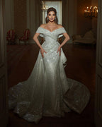 Belle longue robe de mariée sirène à paillettes, sans manches et décolletée épaules dénudées