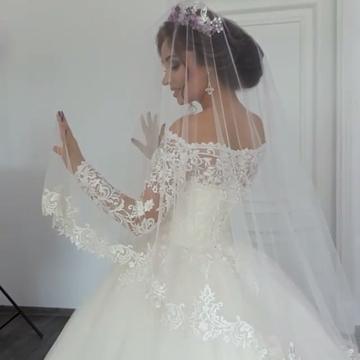 Bellissimo abito da sposa principessa con maniche lunghe scoperte e applicazioni in pizzo