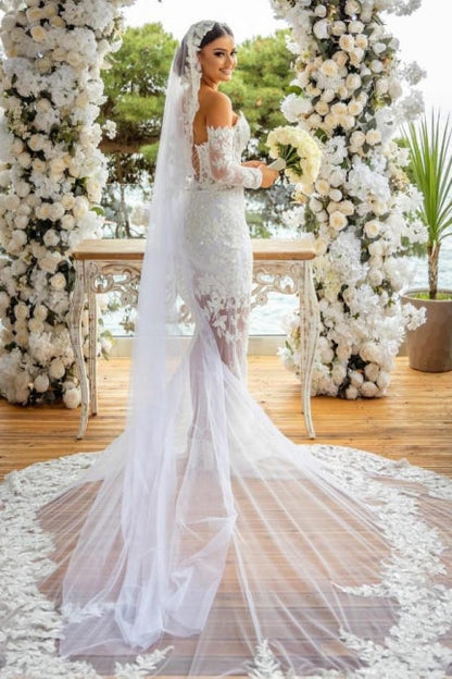 Hermoso vestido de novia largo blanco de sirena con hombros descubiertos, encaje brillante y mangas largas