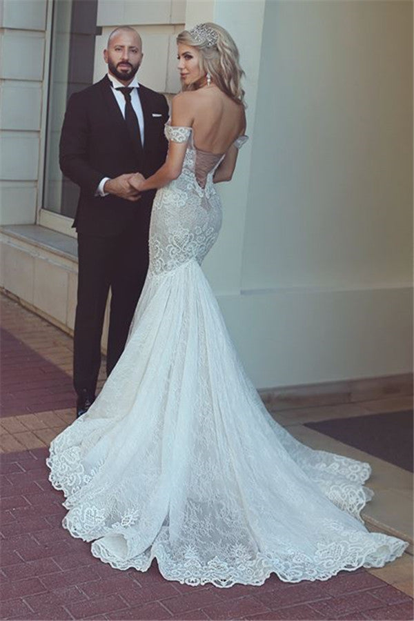 Hermoso vestido de novia de sirena con encaje y hombros descubiertos.
