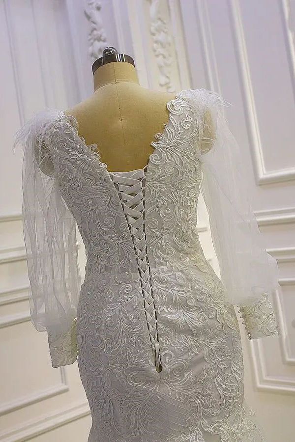 Hermoso vestido de novia de sirena con mangas largas y apliques de encaje y cola