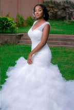 Belle robe de mariée sirène à col en V sans manches ornée de perles