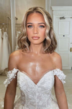 Belle robe de mariée princesse à encolure bardot, coupe évasée, ornée d'appliques, avec traîne