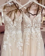 Vestido de novia elegante de tul con escote en V, tirantes finos largos y apliques de encaje.