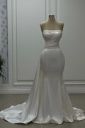 Robe de mariée ivoire en satin, bustier sans bretelles ni manches, ornée de perles, style sirène de créateur
