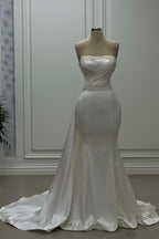 Robe de mariée ivoire en satin, bustier sans bretelles ni manches, ornée de perles, style sirène de créateur