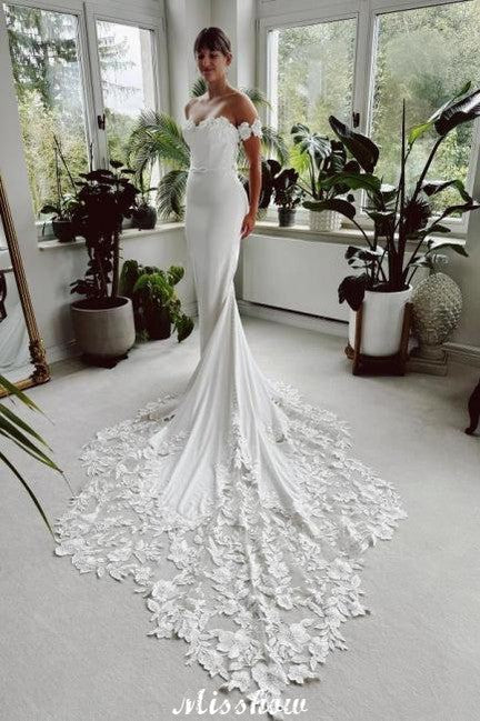 Robe de mariée blanche longue élégante style sirène avec dentelle et traîne, décolletée épaules dénudées
