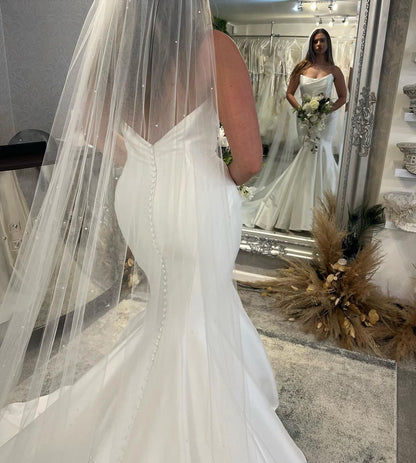 Elegante vestido de novia de satén estilo sirena, sin mangas, largo hasta el suelo y con volantes