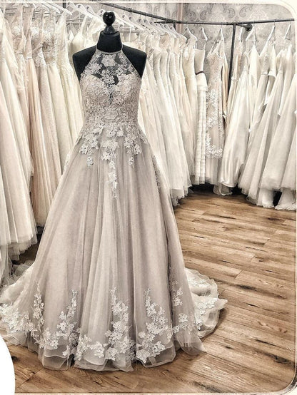 Elegante vestido de novia largo de corte A con cuello halter, espalda descubierta, apliques de encaje, tul, volantes y cola