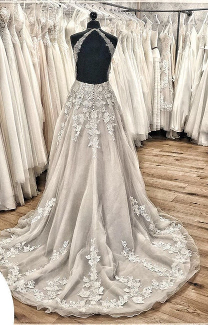 Elegante vestido de novia largo de corte A con cuello halter, espalda descubierta, apliques de encaje, tul, volantes y cola